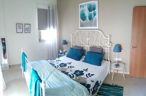 帕福斯Kerynia Apartments的一间卧室配有一张带蓝色枕头的大床