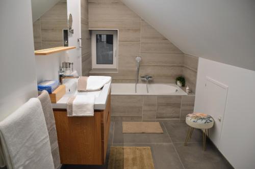 雷杜Plumes et Pinceaux的浴室配有盥洗盆和浴缸。