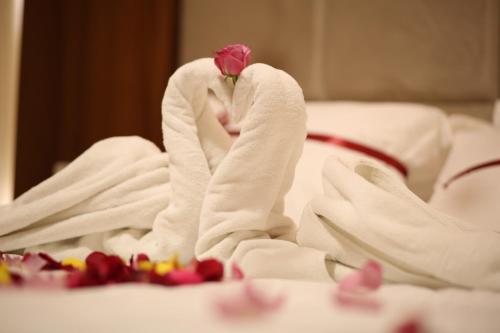 麦地那ريف قباء للشقق الفندقيه的玫瑰坐在床上的毛巾里