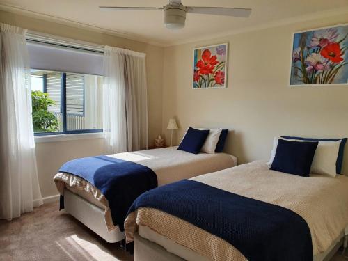 莱克斯恩特伦斯Abalone Guest Accommodation的一间卧室设有两张床和窗户。