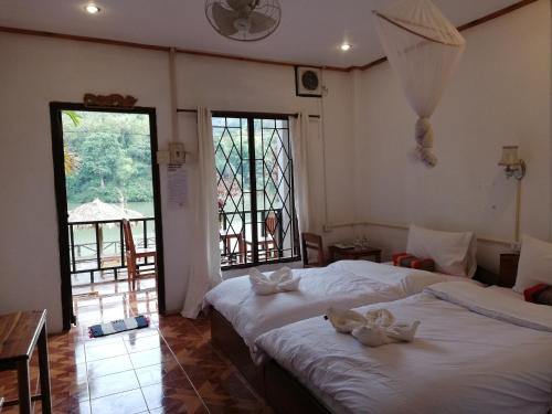 Nongkhiaw南乌河旅舍的一间卧室配有两张带毛巾的床