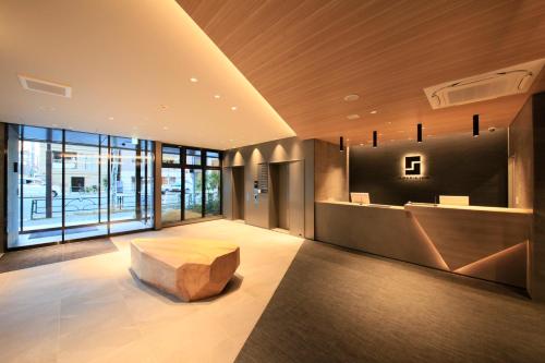 东京S-peria Inn Nihombashi Hakozaki的大厅,房间中间设有长凳