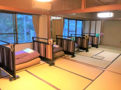 箱根K's House Hostels - Hakone Yumoto Onsen的一间位于地板上并配有三张双层床的客房