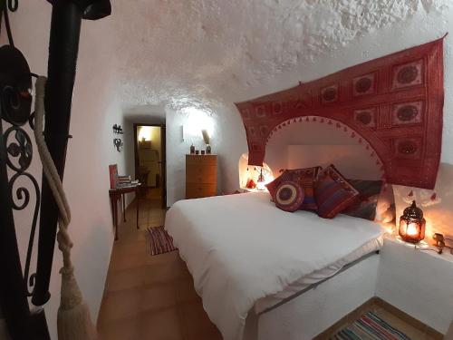 GaleraCuevas Galera - Cuevas de la Luz的一间卧室配有一张大床和红色床头板