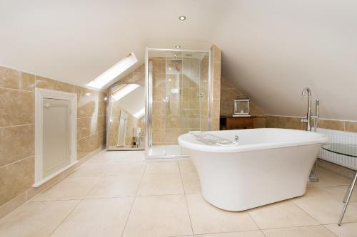 惠特比Drake Cottage的大型浴室设有浴缸和淋浴。