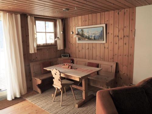 策尔内茨Chesa Sper l'Ovel Brail的一间带木桌和窗户的用餐室