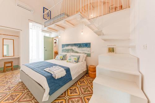 莫尔恰诺迪莱乌卡VERDEACQUA CASA VACANZE的一间卧室设有一张床和一个楼梯