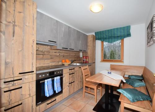 瓦尔赫湖Haus Salvenmoser的厨房配有木制橱柜和木桌。