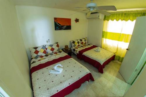 圣安德烈斯Posada Caribbean Refuge的一间卧室配有两张床和吊扇