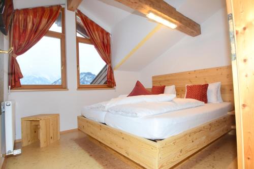瓦尔赫湖Haus Salvenmoser的一间带木床的卧室,位于带窗户的客房内
