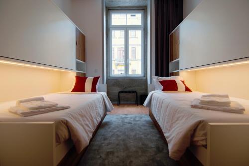 布拉加HI Braga - Pousada de Juventude的酒店客房设有两张床和窗户。
