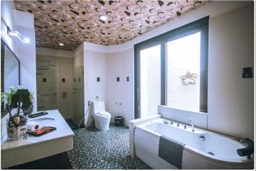 奥隆阿波Segara Villas的带浴缸、盥洗盆和卫生间的浴室