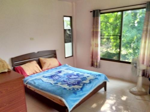 清道Mondala Resort的一间卧室配有一张带蓝色毯子的床
