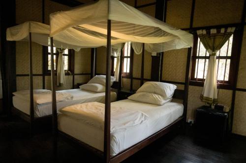 Nongkhiaw农基亚河滨酒店的带窗户的客房内的两张单人床