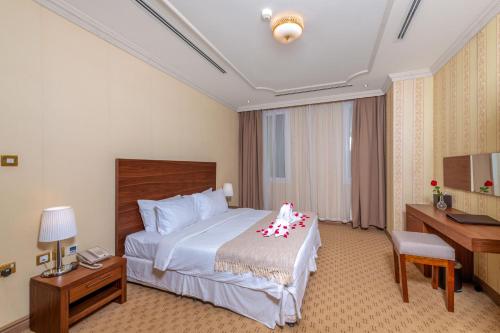 多哈Al Diyafa Furnished Suites的配有一张床和一张书桌的酒店客房
