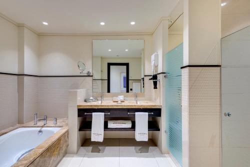 奇克拉纳－德拉弗龙特拉Royal Hideaway Sancti Petri的一间带浴缸和大镜子的浴室