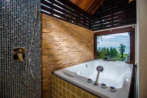 苏梅岛2H RESORT KOH SAMUI的带浴缸的浴室和窗户。