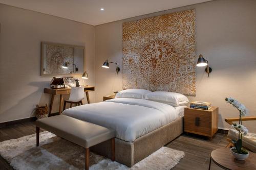 拉各斯The White Orchid Hotel的一间卧室配有一张大床和一张书桌