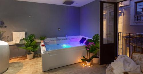 卡塔尼亚Duomo Luxury Suite Catania的浴室设有蓝色浴缸,内有植物