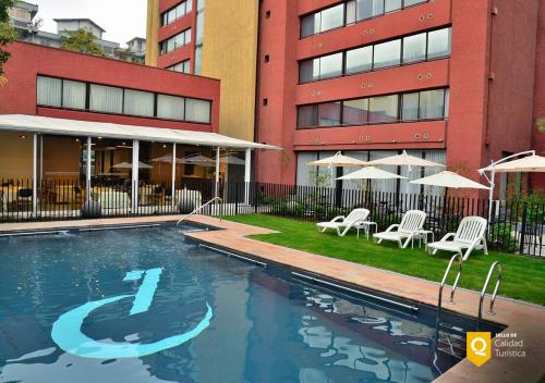 圣地亚哥帕纳美丽嘉纳普罗维登西亚酒店的大楼前的游泳池