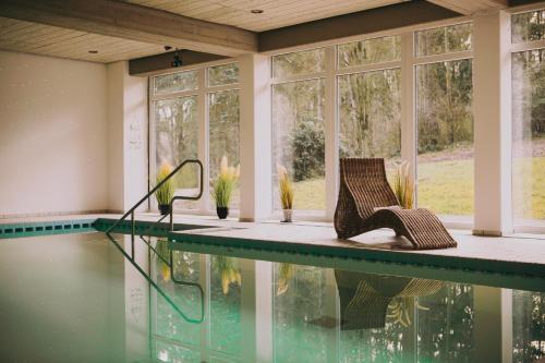 埃克斯特塔尔Hotel Zur Burg Sternberg的房屋设有游泳池、椅子和窗户
