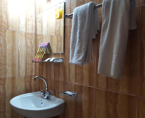 BāndarbanHotel Hill View的浴室配有盥洗盆、镜子和毛巾
