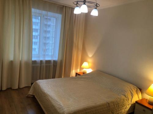 基辅Затишна 2х кімнатна квартира біля метро Академмістечко的一间卧室配有一张床、一个窗口和两盏灯。