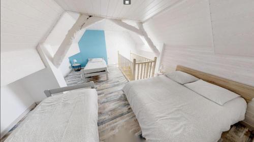 库尔瑟勒·苏尔·梅尔Charmante petite maison de la côte Normande的一间白色客房内带两张床的卧室