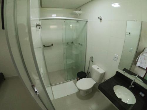 卡皮托利乌Suítes Canaã的带淋浴、卫生间和盥洗盆的浴室