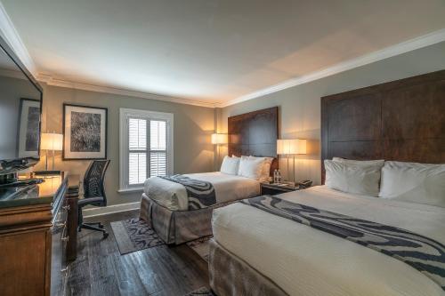 新奥尔良勒马拉斯酒店的酒店客房配有两张床和一张书桌
