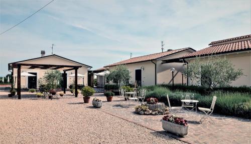 斯佩洛Residence Terra Dei Santi Country House的一座配有桌椅的庭院和一座建筑
