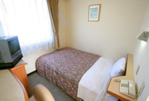 郡山郡山星级酒店的酒店客房配有一张床、一张书桌和一台电视。