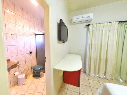 博尼图CLH Suites Bonito Sul的一间带水槽和卫生间的浴室以及一台电视。