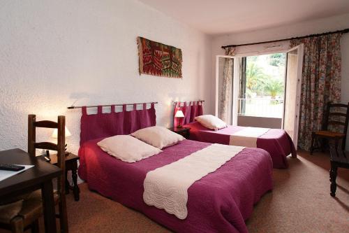 卢恰纳科里布里酒店的一间卧室设有两张床、一张桌子和一个窗口。