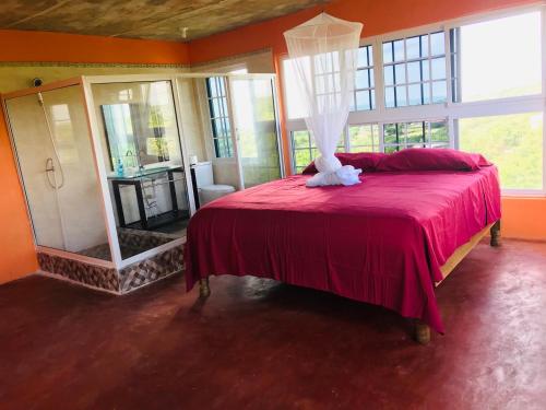 特雷热比奇欢迎瓦布斯旅馆的一间卧室配有红色的床和镜子