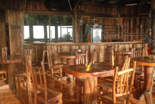 Cabecera de CañasCabañas Don Camilo Albergue de Montaña的餐厅内带木桌椅的酒吧