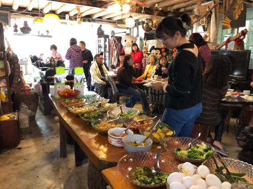 泰安乡云梦山林民宿 的一群人坐在餐桌旁吃着食物