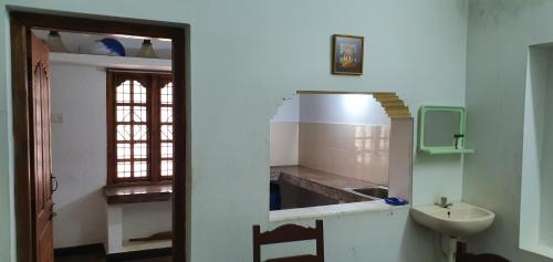 库塔兰Podhigai Garden Villa的一间带水槽和卫生间的浴室以及窗户。