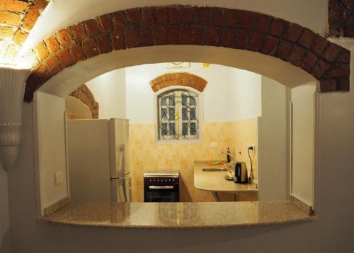 卢克索Malkata House的厨房设有拱门,厨房配有冰箱