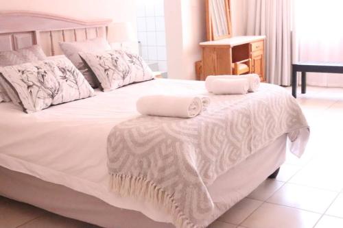 贝拉贝拉Die Huis - Self Catering的一张白色的床,上面有两条毛巾