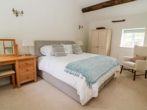 斯基普顿Croft Cottage的一间卧室配有一张床、一张桌子和一把椅子