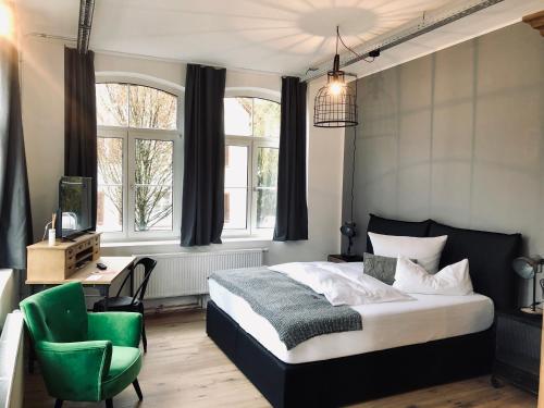 特罗辛根KunstWerk B的一间卧室配有一张床和一把绿色椅子