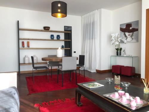 菲乌米奇诺Nativo Suite Da Vinci 25的客厅配有桌子和红色地毯