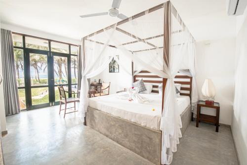 阿洪加拉Villa Nilnara的一间卧室配有一张带天蓬的床