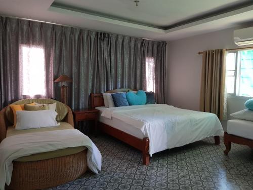 乌隆他尼纳迪度假屋的酒店客房设有两张床和窗户。