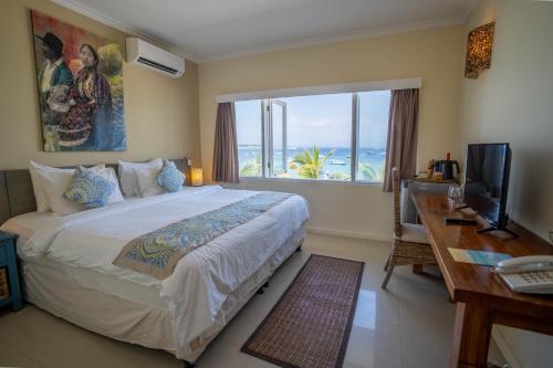 吉利特拉旺安斯凯利威格度假酒店的一间卧室配有一张大床、一张书桌和一个窗户。