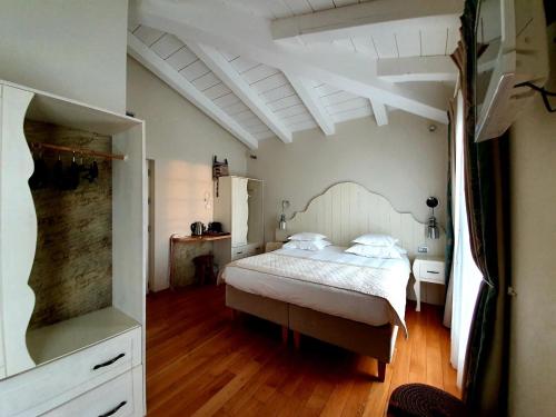 艾日Hôtel Eze Hermitage entre Nice et Monaco的卧室配有白色的床,铺有木地板