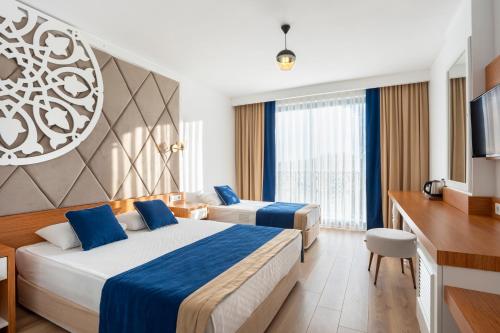 马纳夫加特The Sansa Hotel & Spa的酒店客房设有两张床和电视。