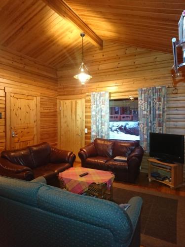 VihtavuoriKuhajärven Suviranta cottage的客厅配有真皮沙发和电视