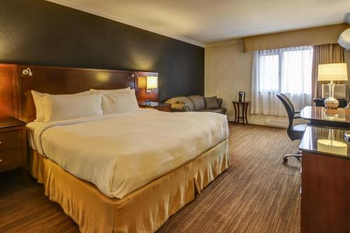 萨格奈拉萨格奈 - 酒店及会议中心的酒店客房设有一张大床和一张书桌。